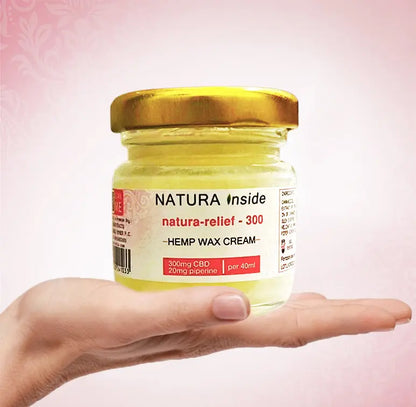 Hemp wax cream jar with gold lid, held in hand
